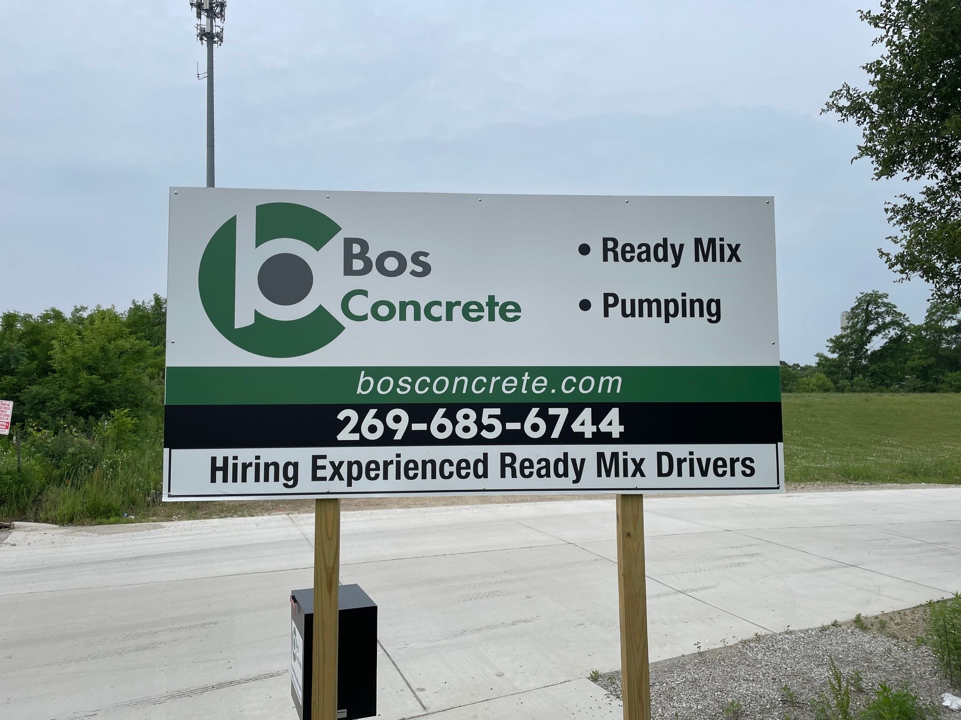 Sign for Bos Concrete: logo, services (ready mix, pumping), website, phone number, and driver hiring.