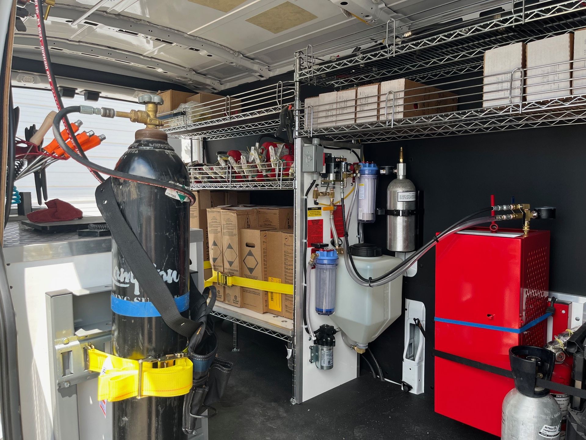 The inside of a van filled with lots of equipment and boxes.