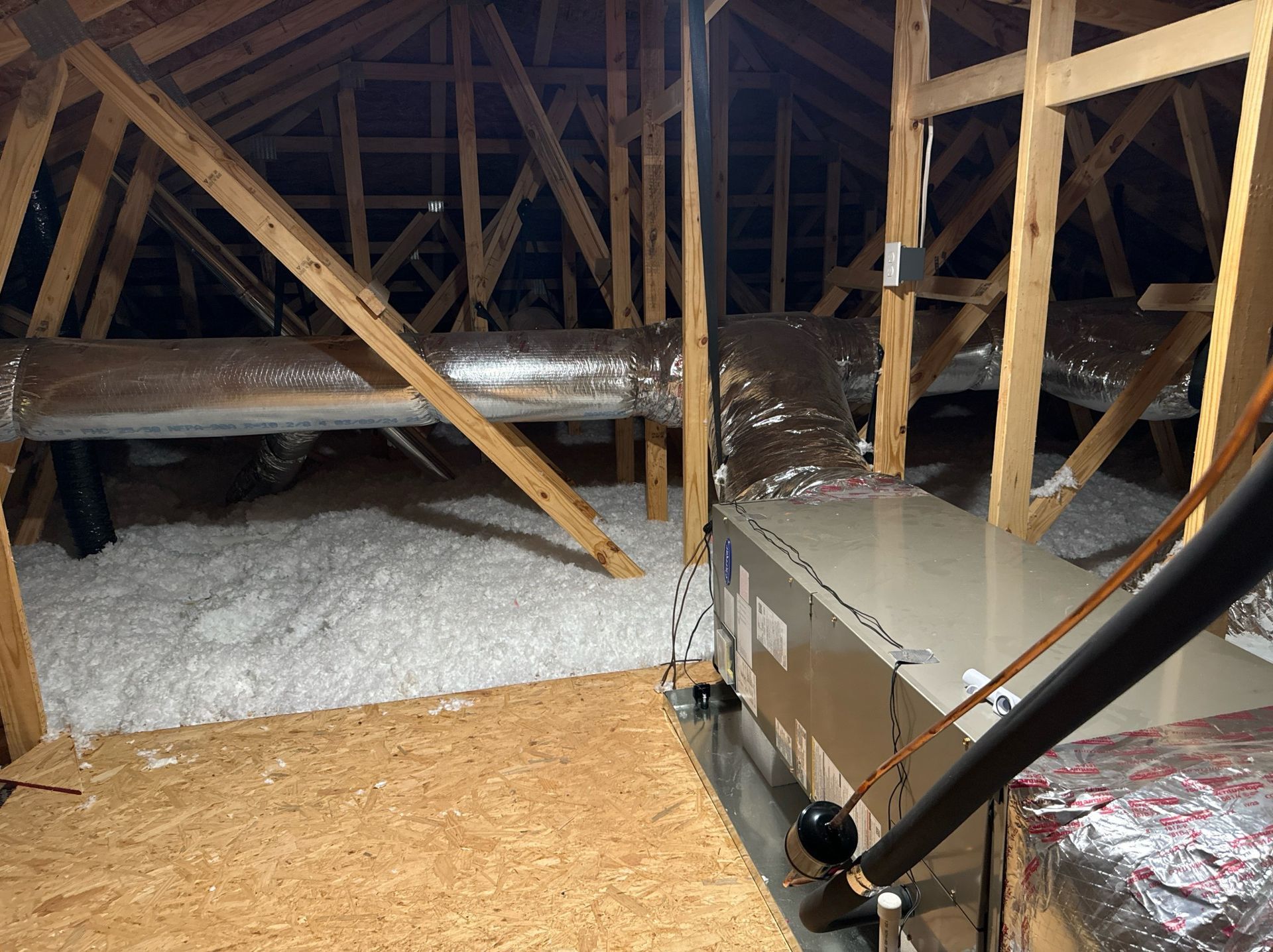 An attic with a lot of pipes going through it