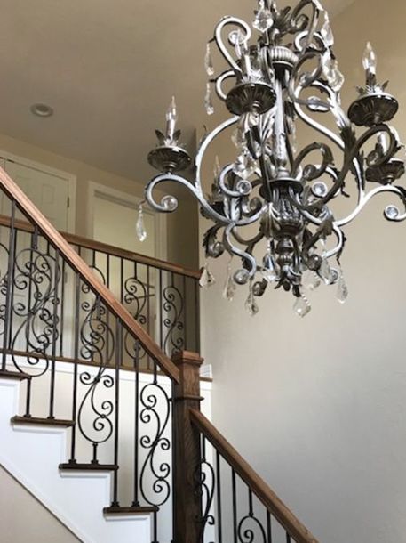 a chandelier hanging from the side of a stair case