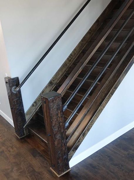 a wooden stair case with a metal handrail