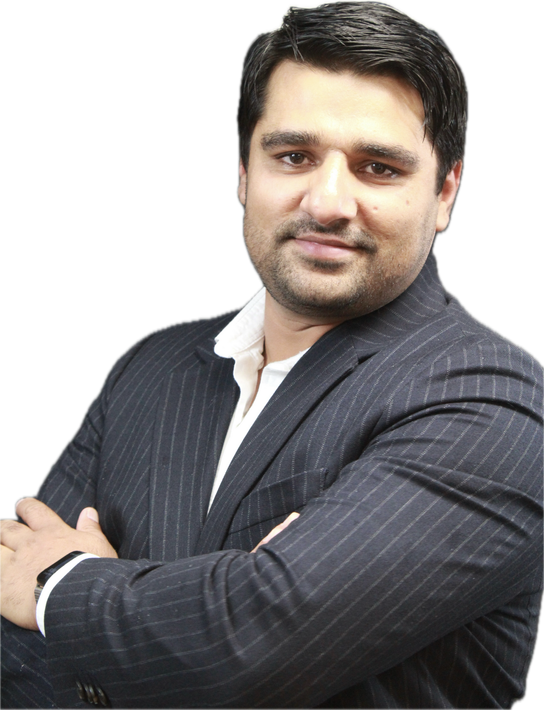 A woman is sitting at a desk with a laptop and a vase of flowers.