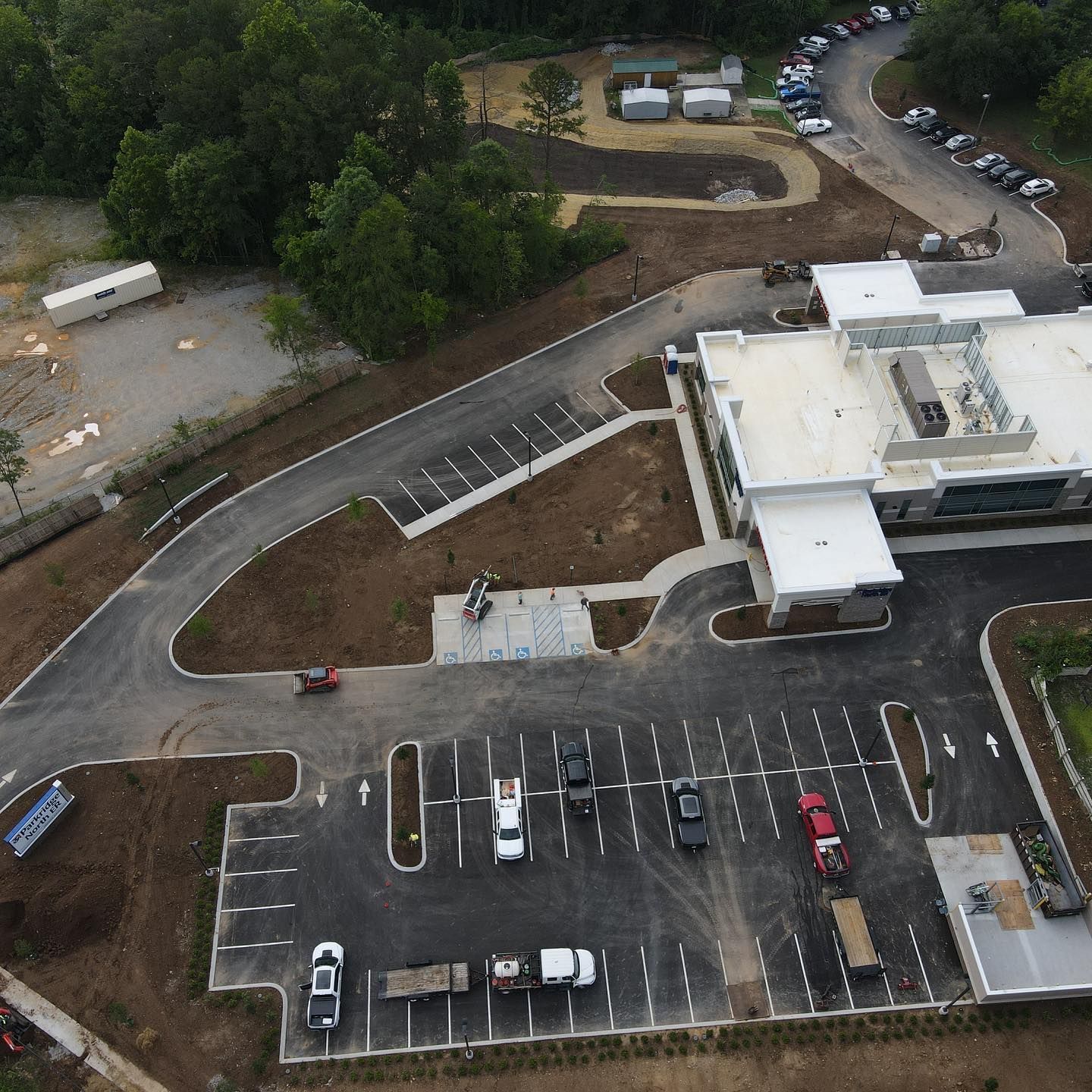 An aerial view of a parking lot with a building in the background