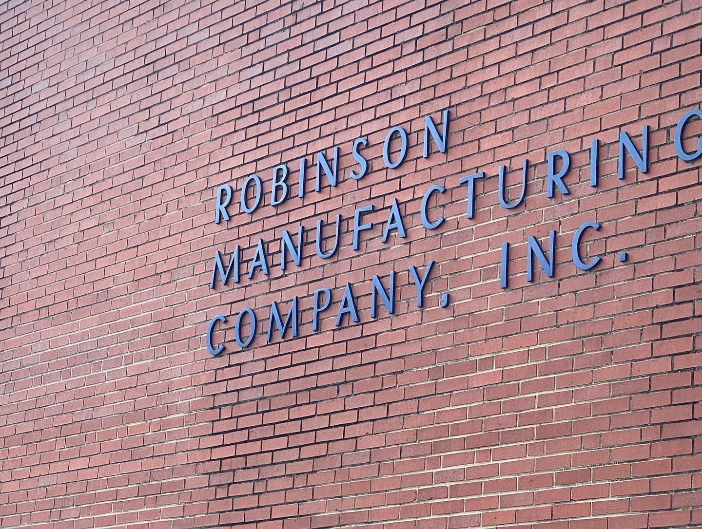 A brick wall with the words robinson manufacturing company written on it