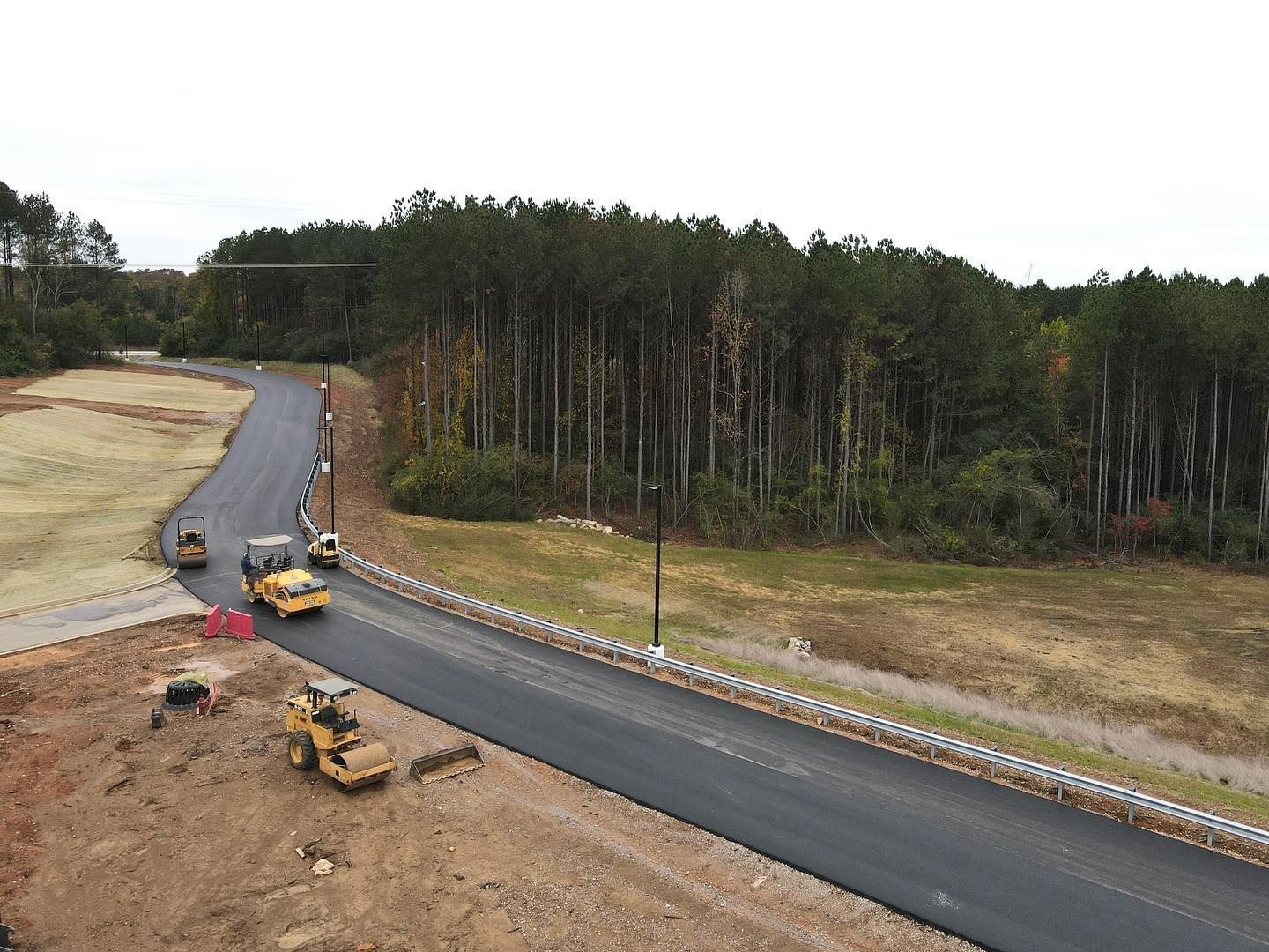 An aerial view of a road going through a forest.