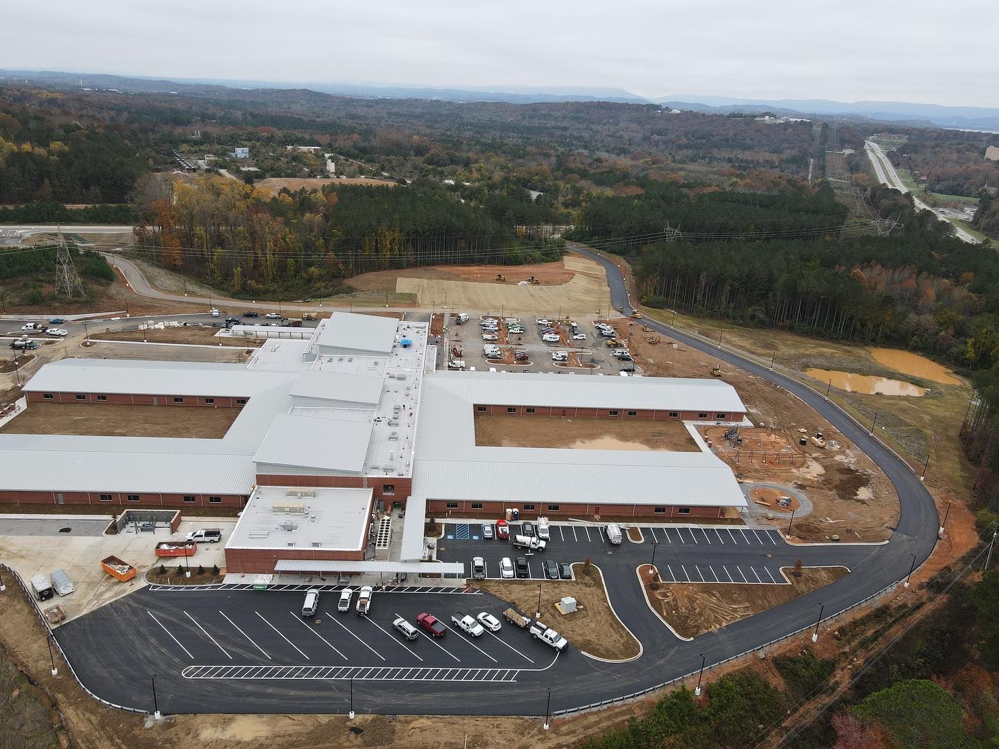 An aerial view of a large building with a parking lot in front of it.