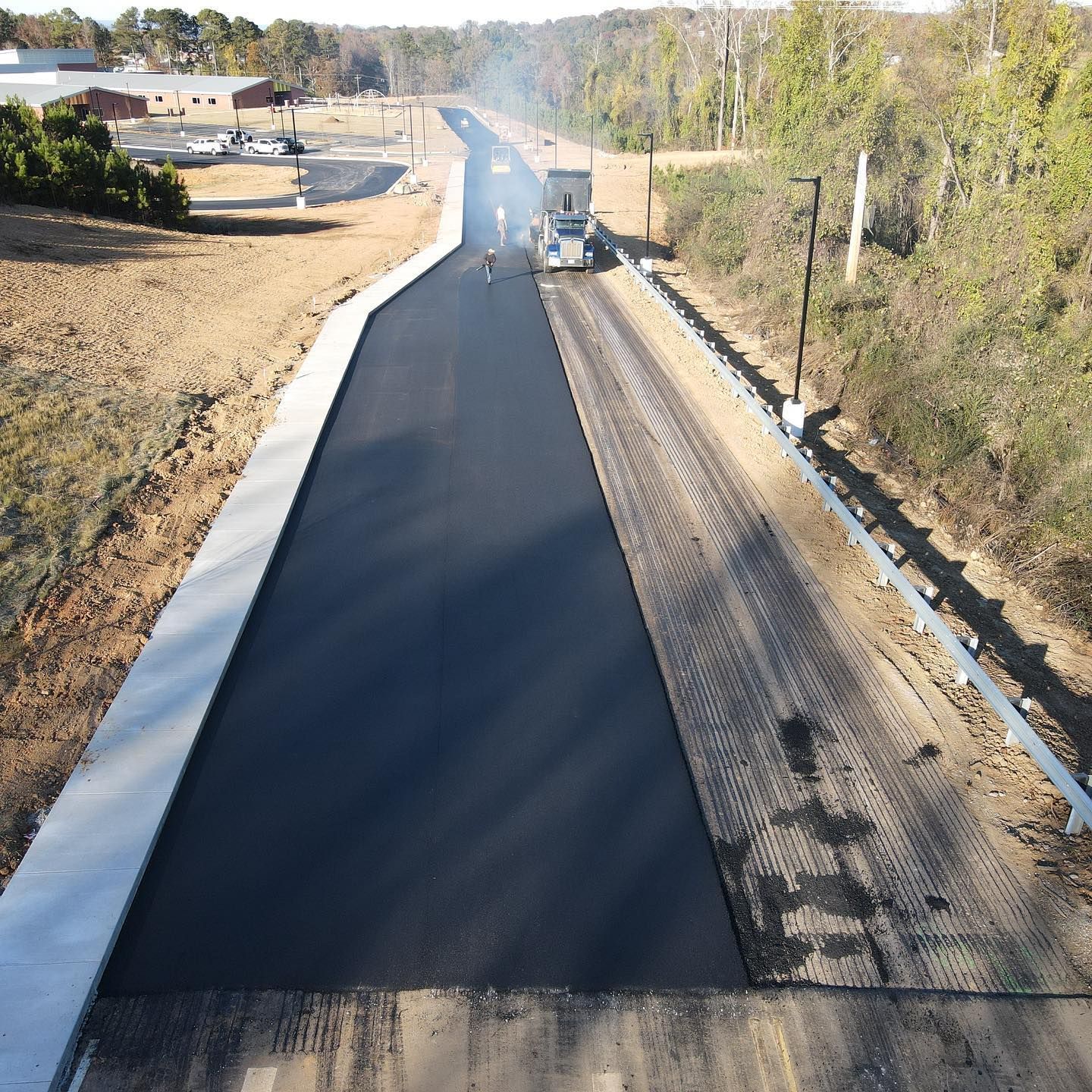 An aerial view of a road that is being paved