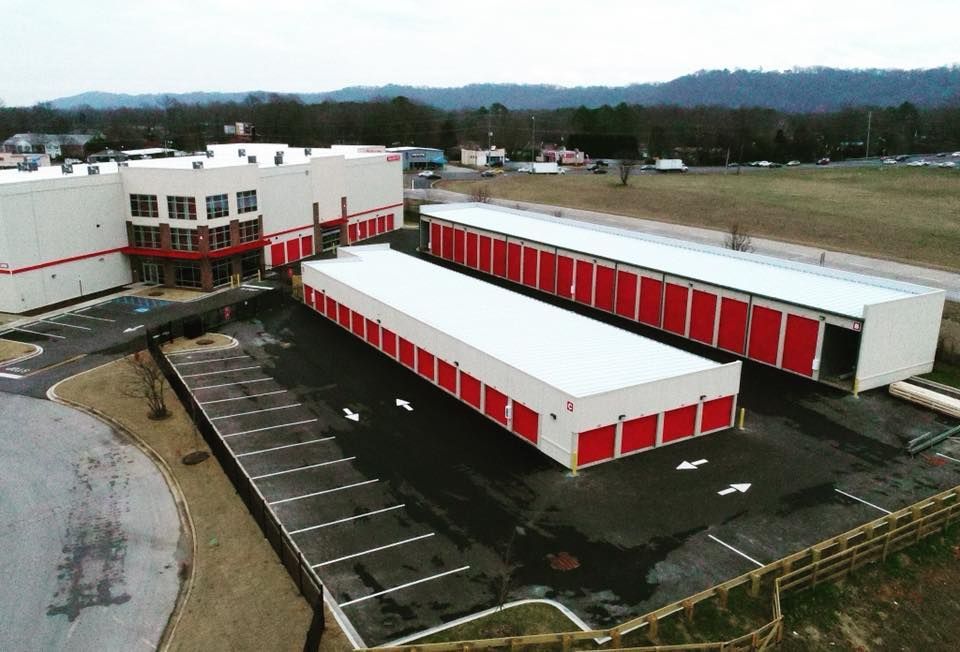 An aerial view of a storage facility with red and white buildings and a parking lot.