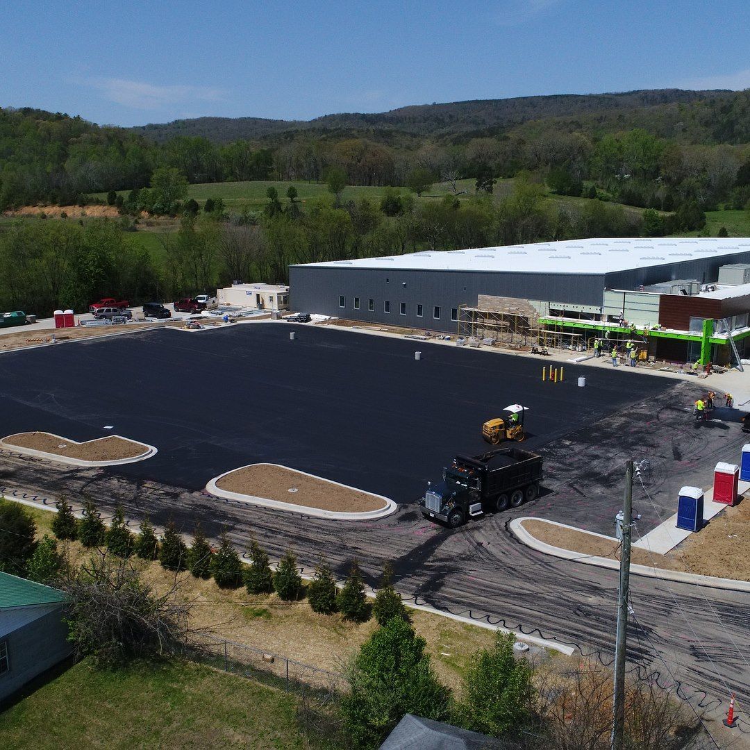 An aerial view of a large parking lot with a building in the background
