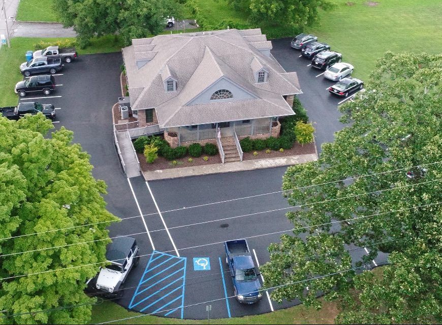 An aerial view of a building with a lot of cars parked in front of it