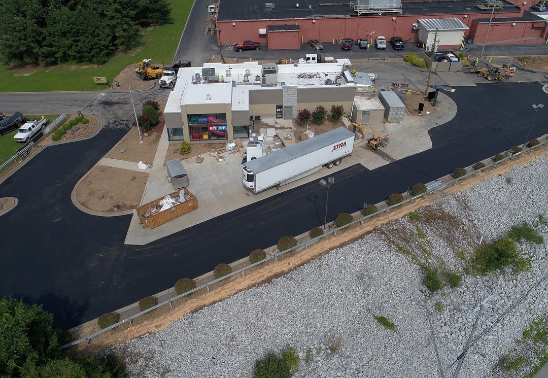 An aerial view of a large building with a truck parked in front of it.