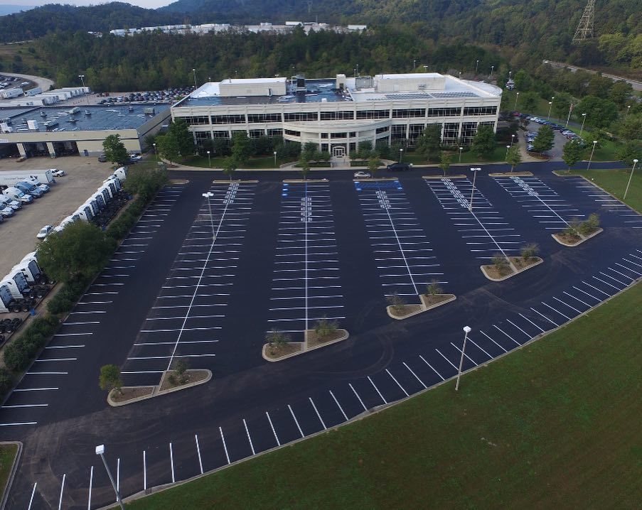 An aerial view of a parking lot in front of a large building