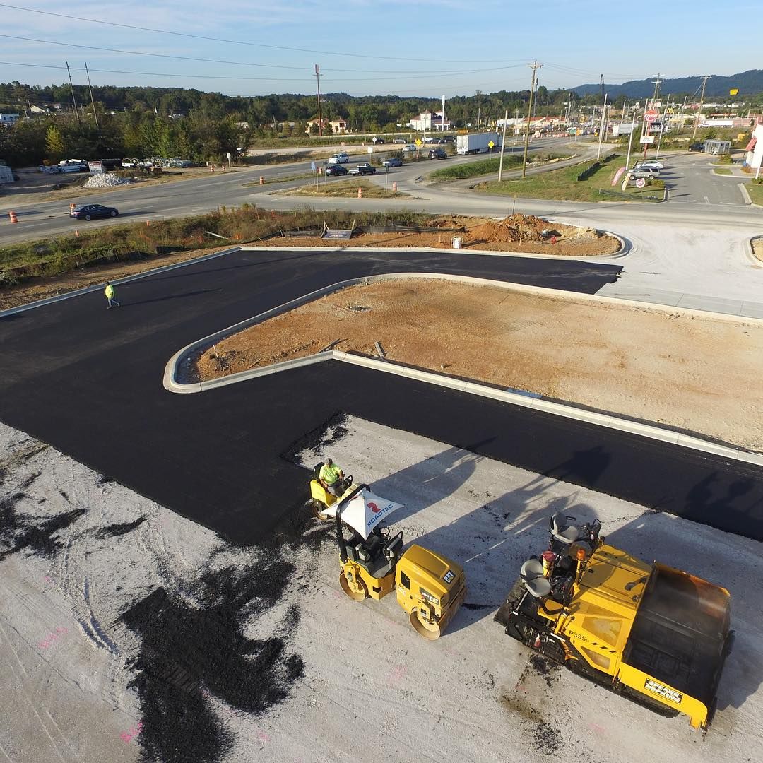 An aerial view of a road being paved with a yellow roller