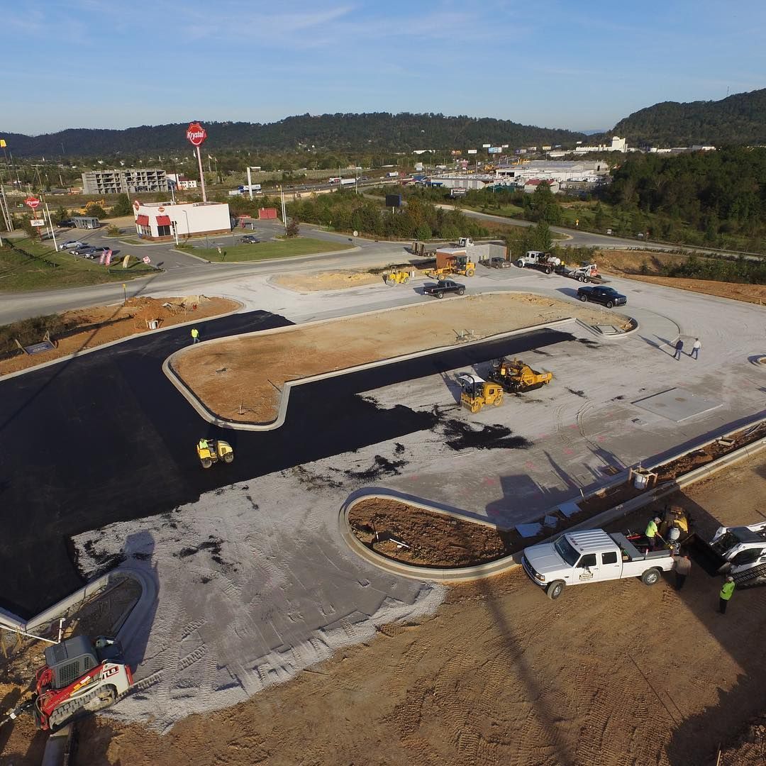 An aerial view of a construction site with trucks parked on the side of the road.