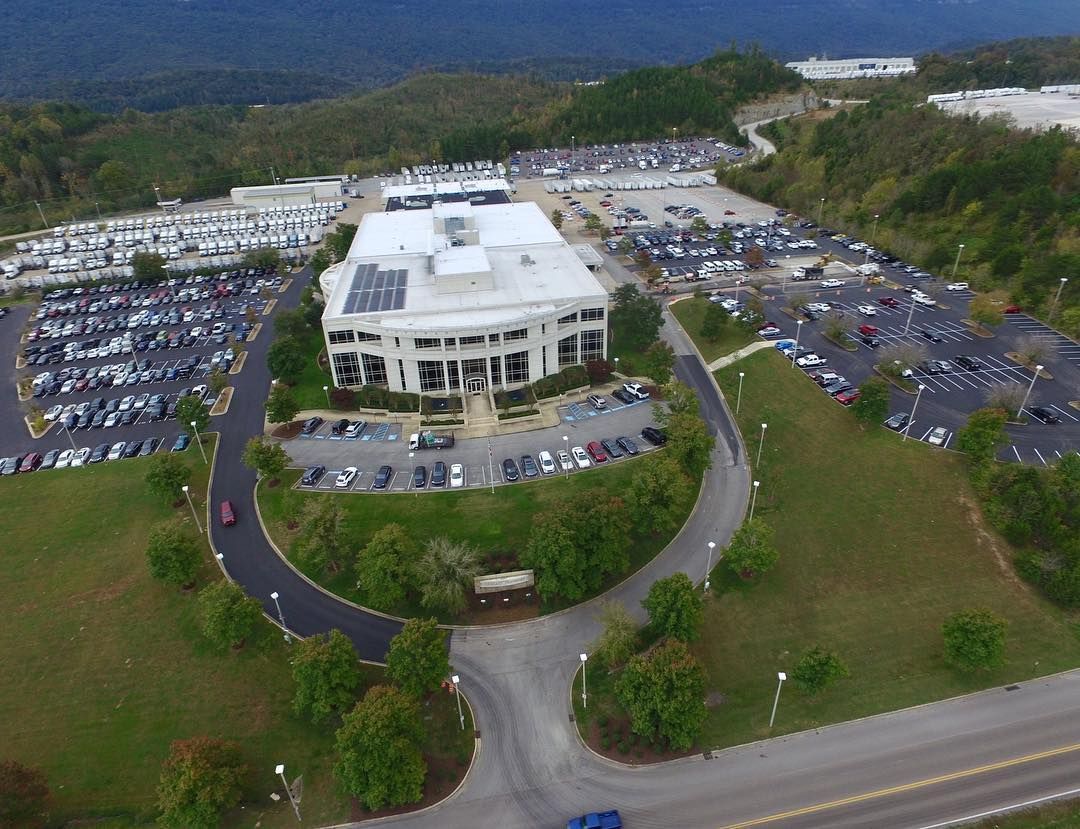 An aerial view of a large building surrounded by parking lots