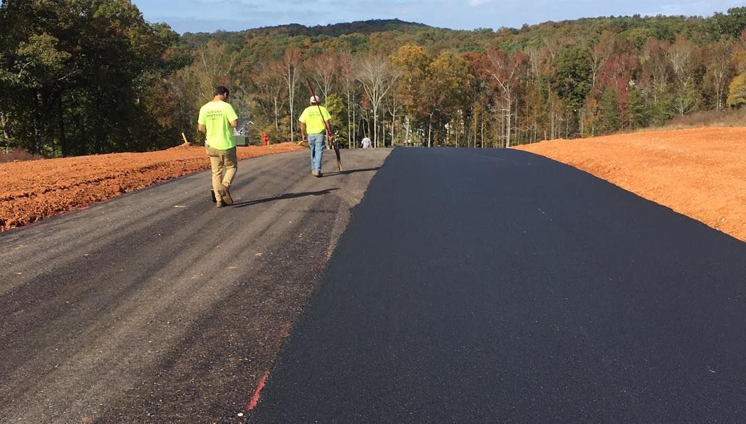 Two men are walking down a newly paved road.