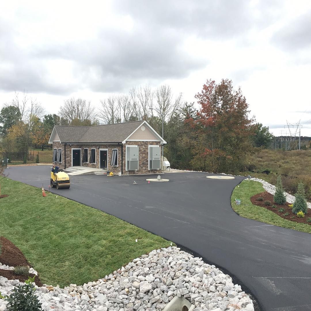 A yellow golf cart is driving down a road in front of a house.