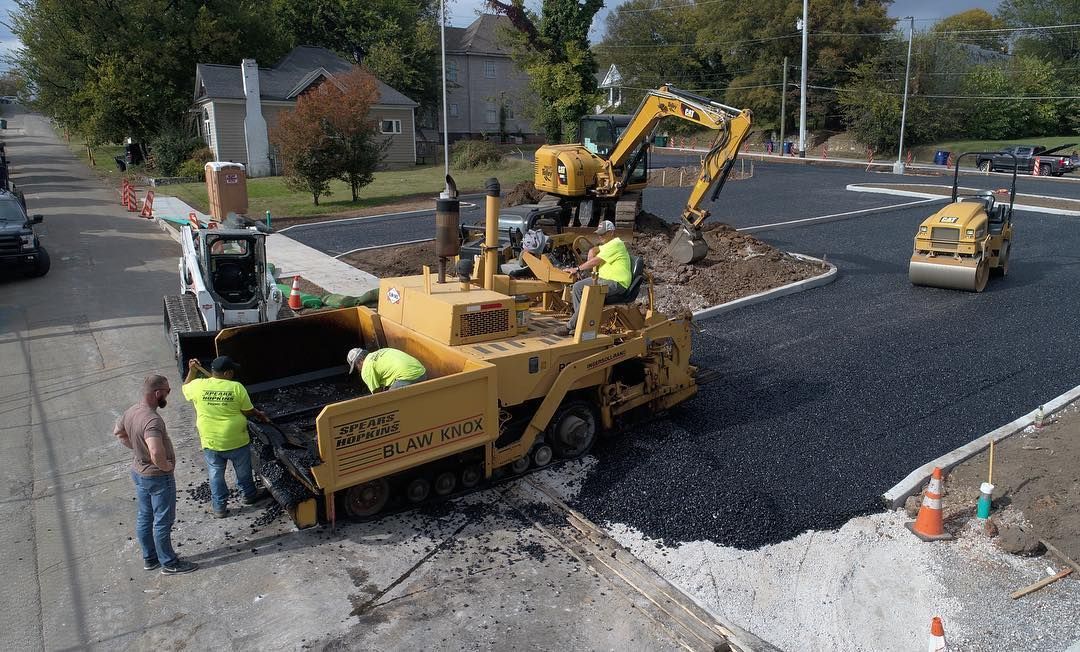 A group of construction workers are working on a road.