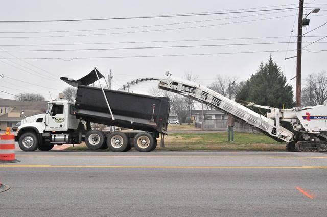 A cat bulldozer is driving down a dirt road
