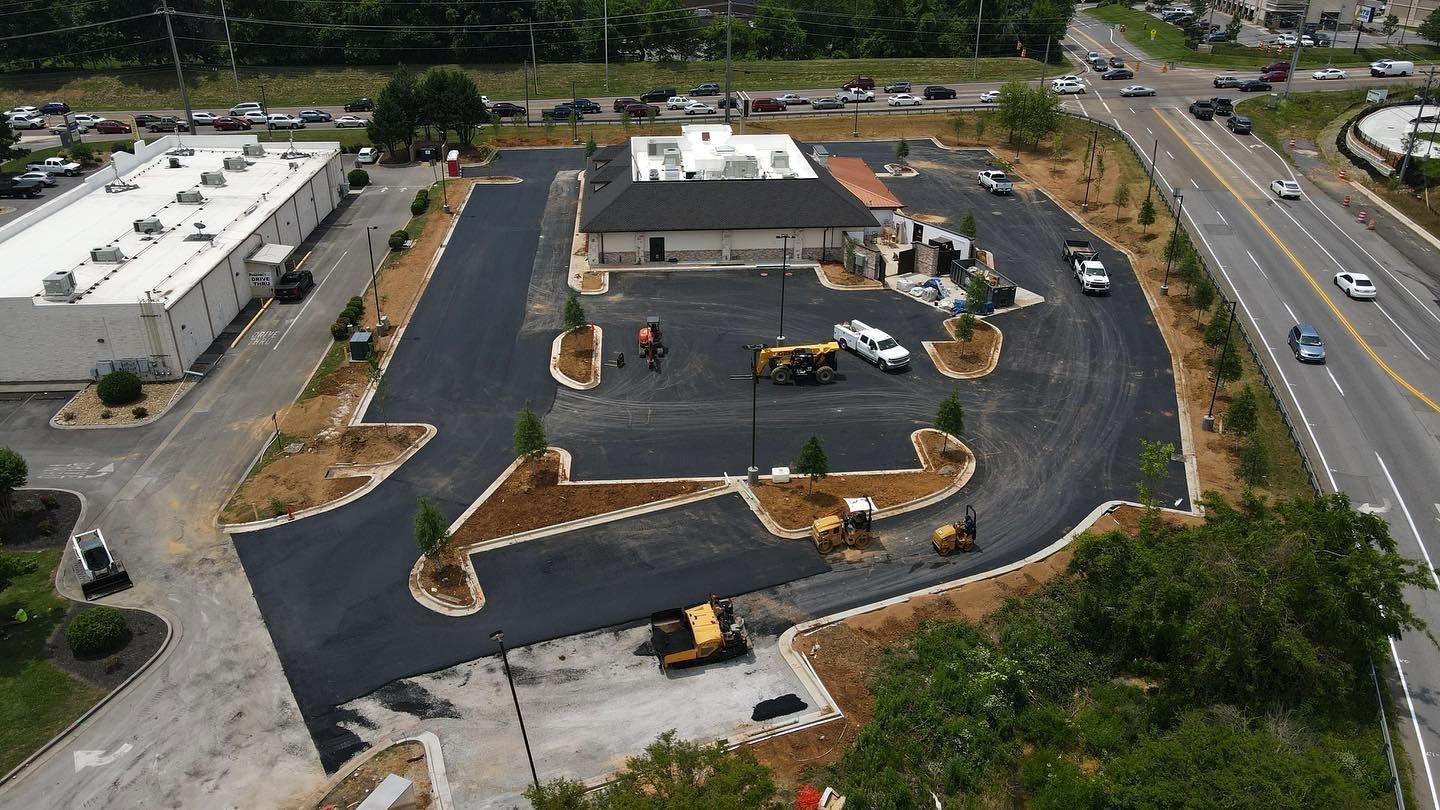 An aerial view of a parking lot being built next to a highway.