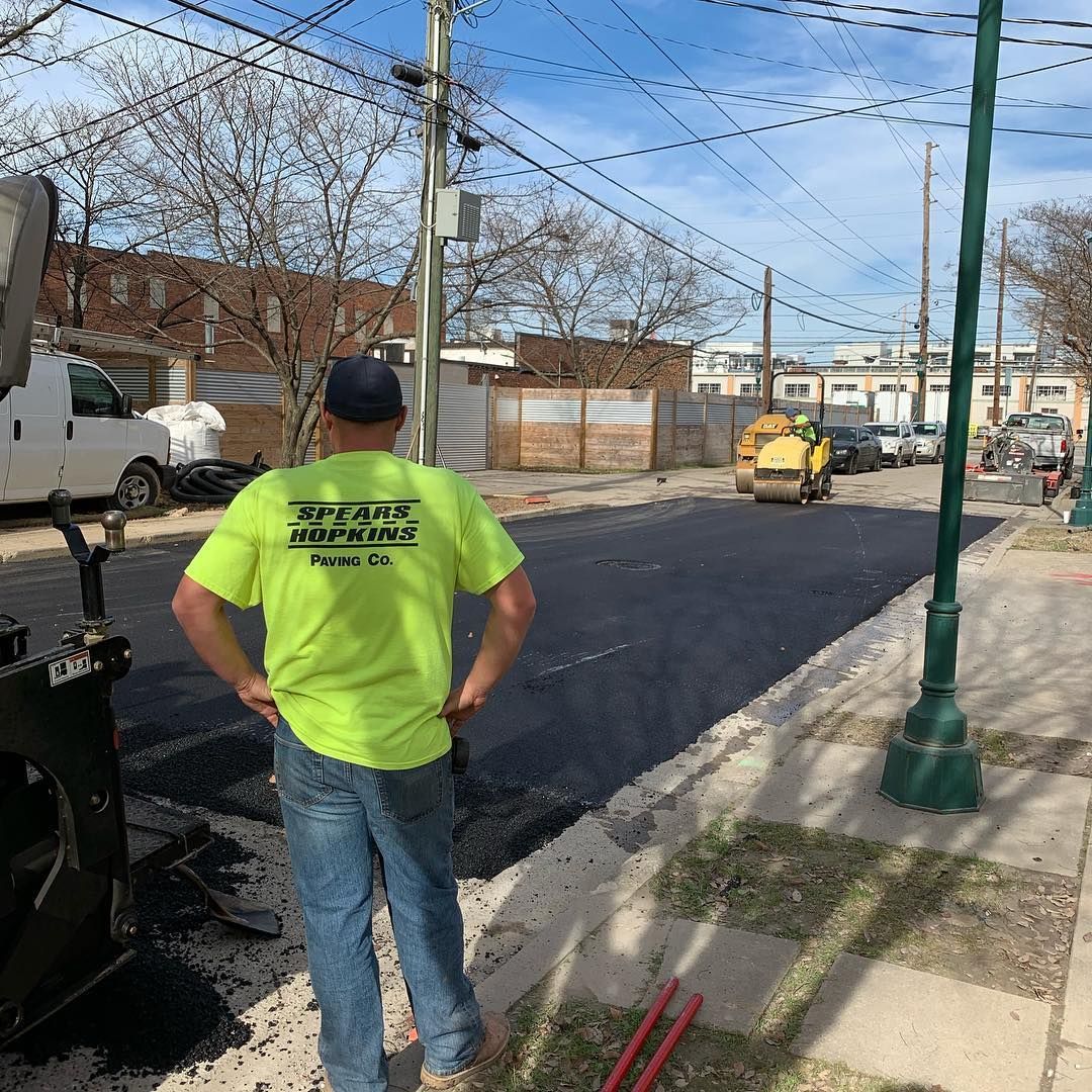 A man in a neon yellow shirt is standing on the sidewalk