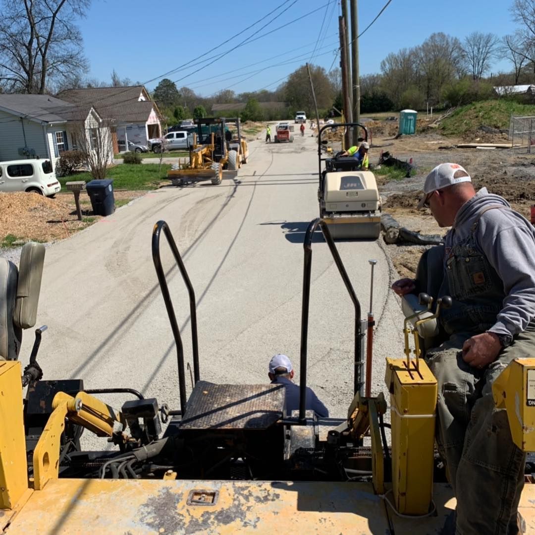 A man sits on the back of a construction vehicle