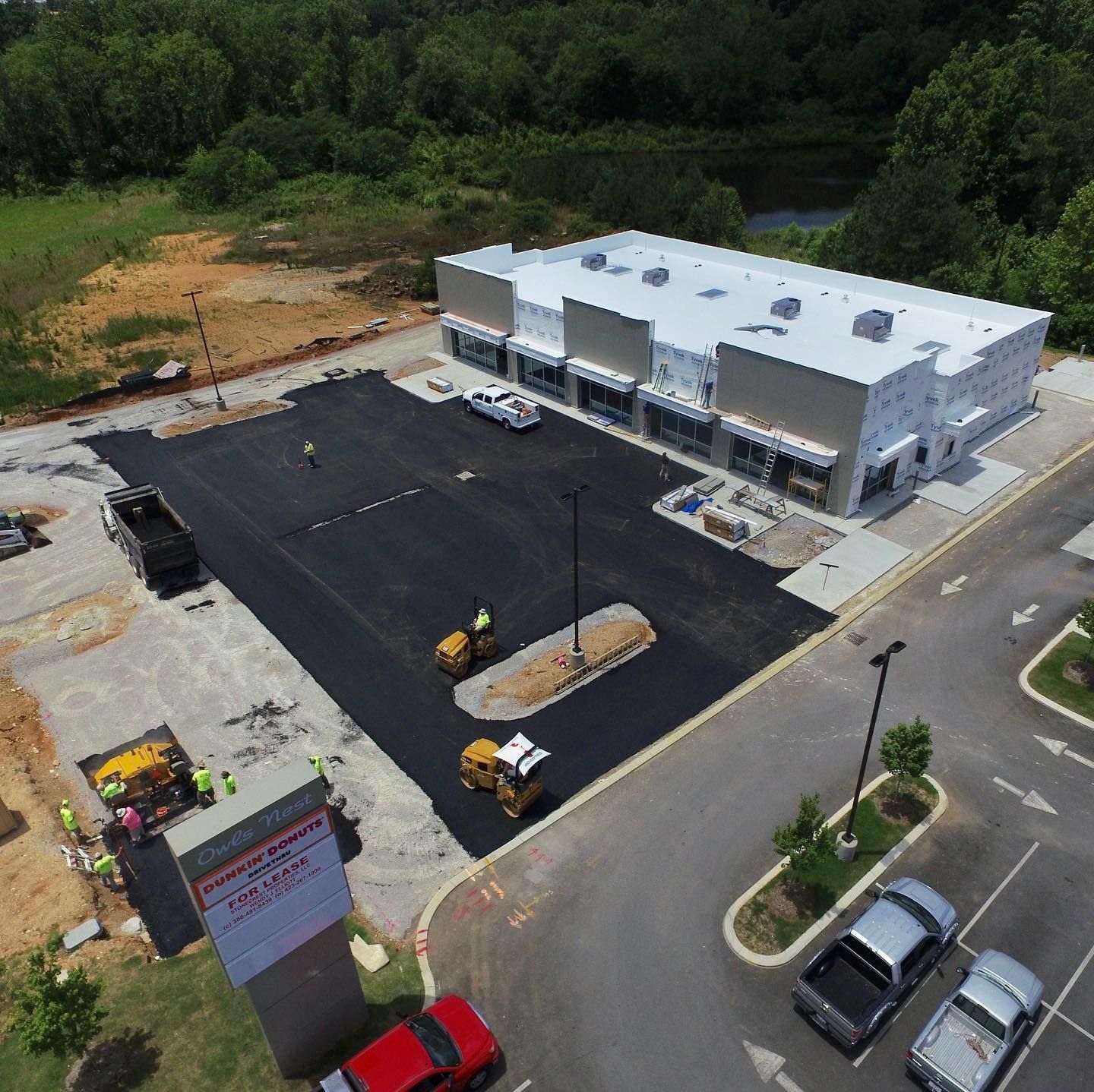An aerial view of a parking lot with a building in the background