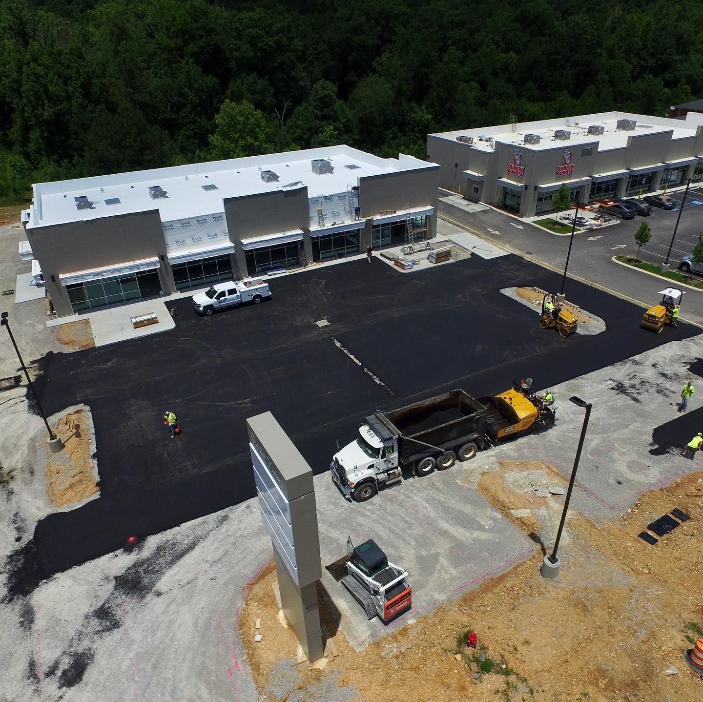 An aerial view of a parking lot with a dump truck parked in front of a building.