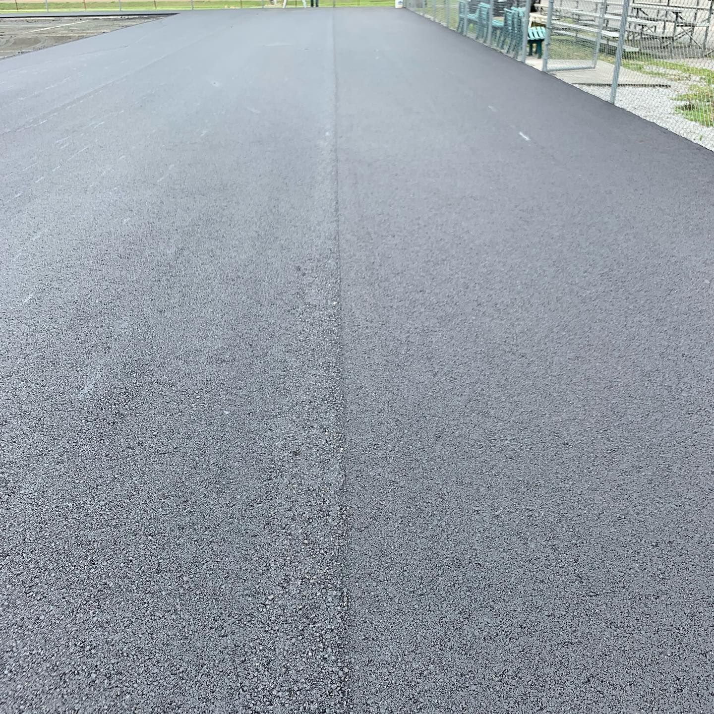 A close up of a road with a fence in the background
