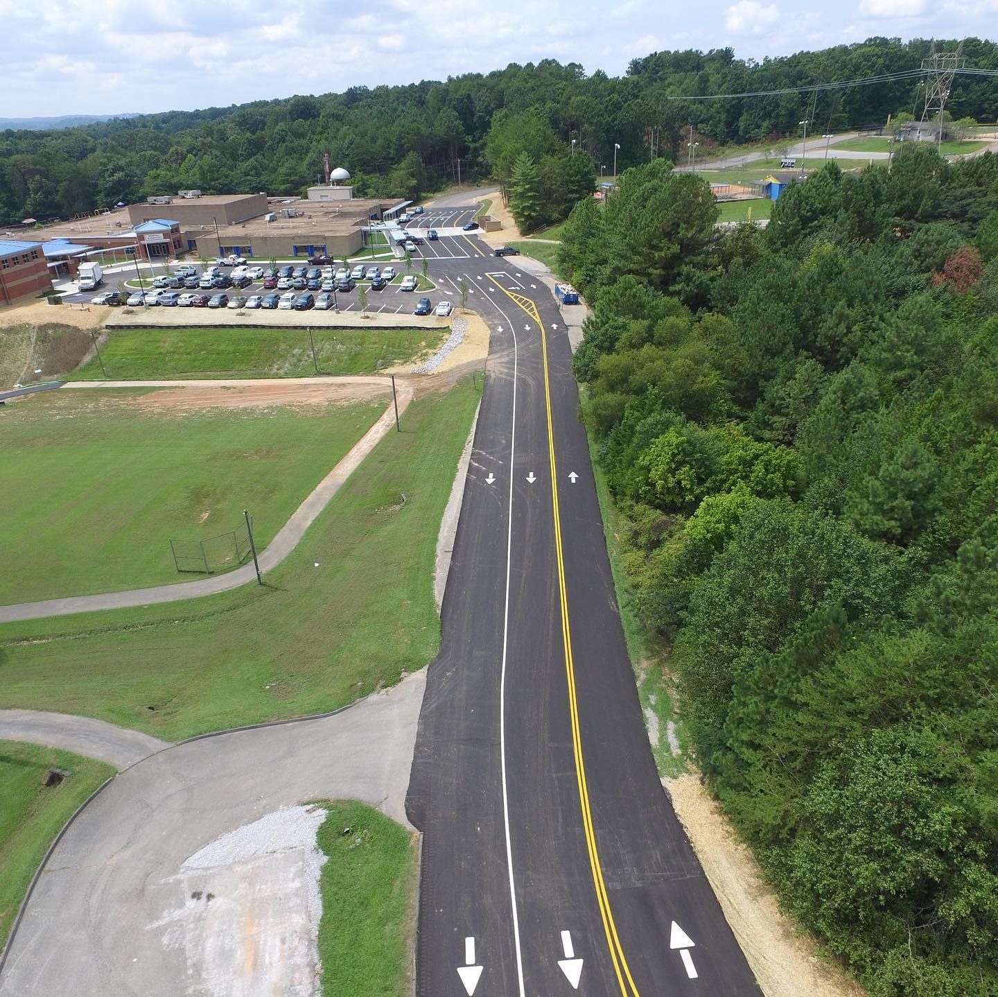 An aerial view of a road with arrows pointing in opposite directions