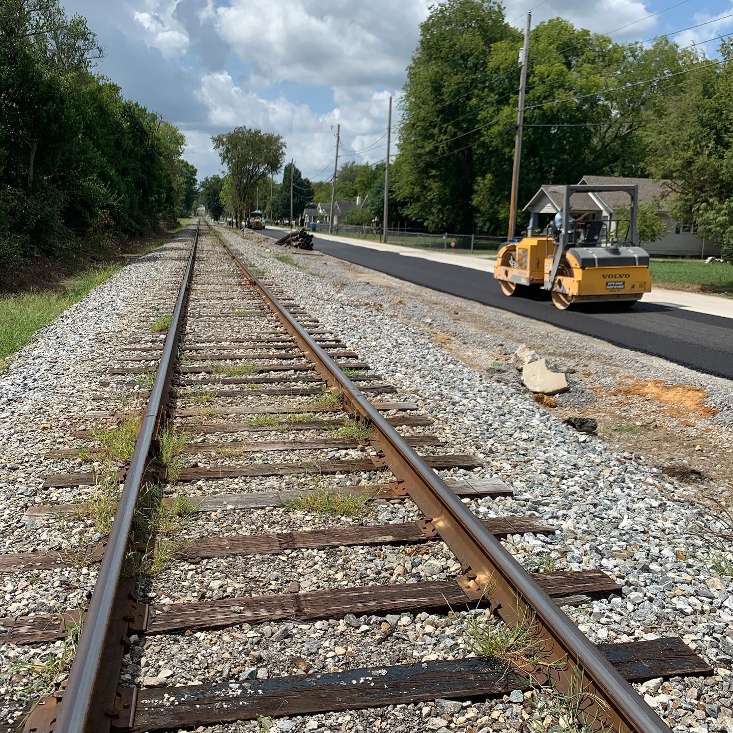 A yellow vehicle is driving down train tracks