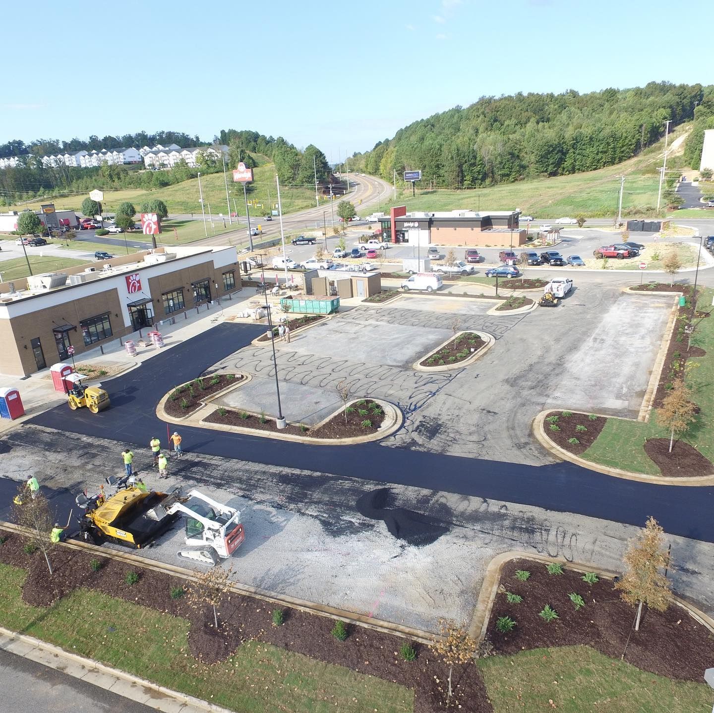 An aerial view of a parking lot with a lot of cars parked in it