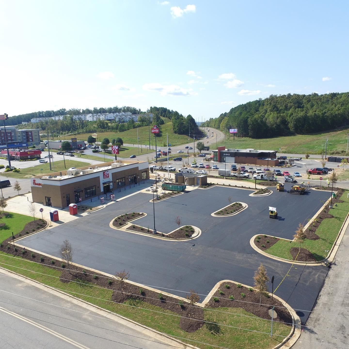 An aerial view of a parking lot with a building in the background