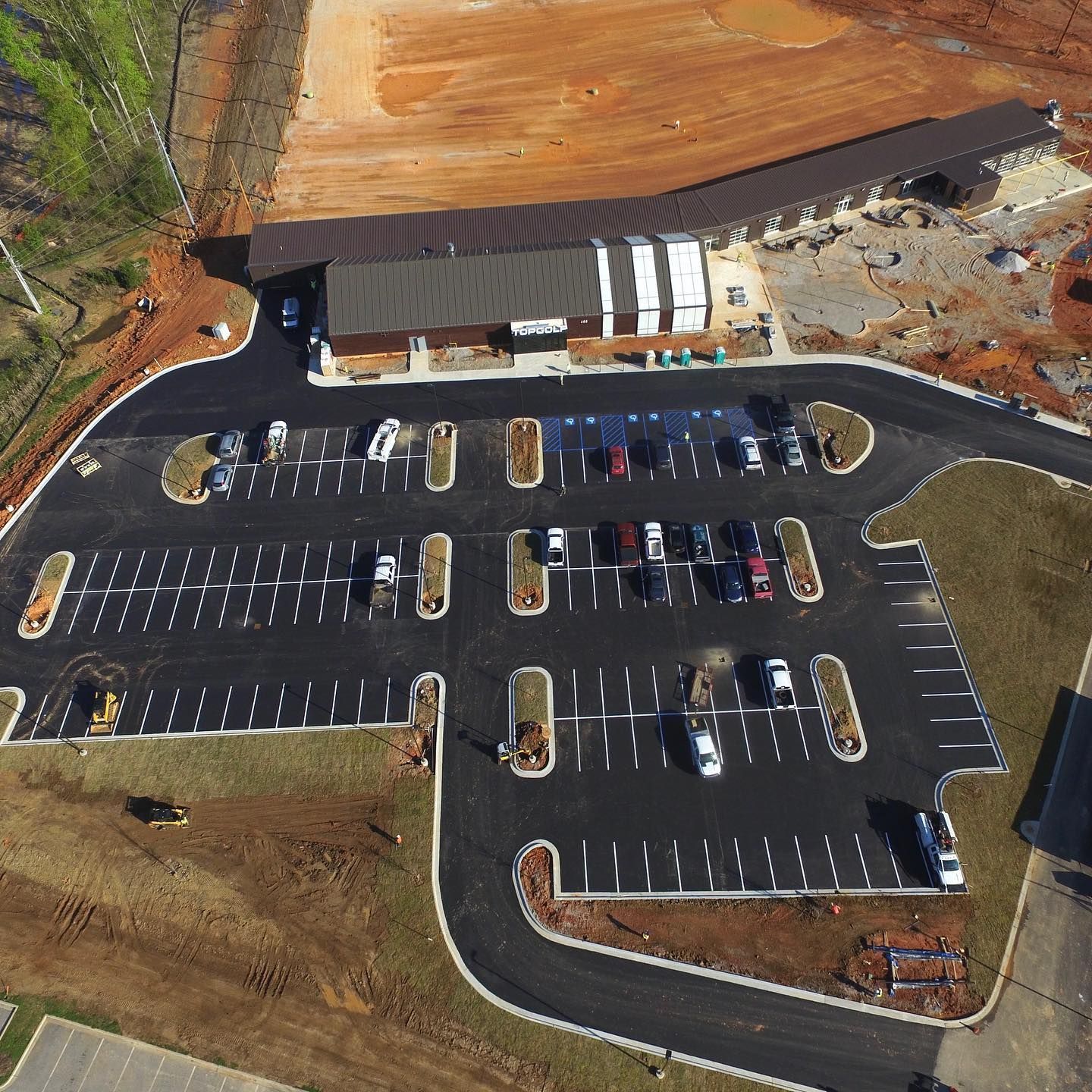 An aerial view of a parking lot with a building in the background