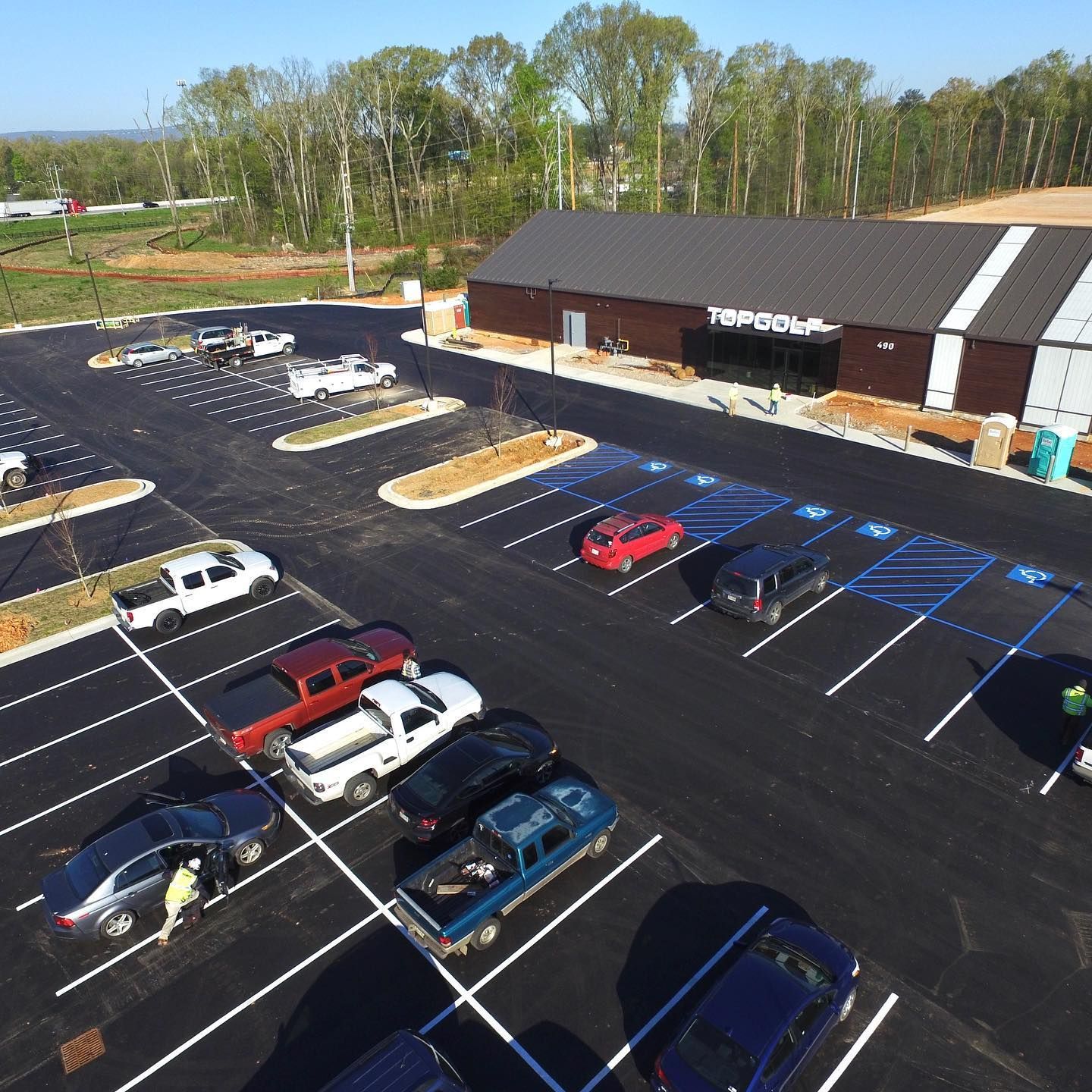 An aerial view of a parking lot with a store in the background