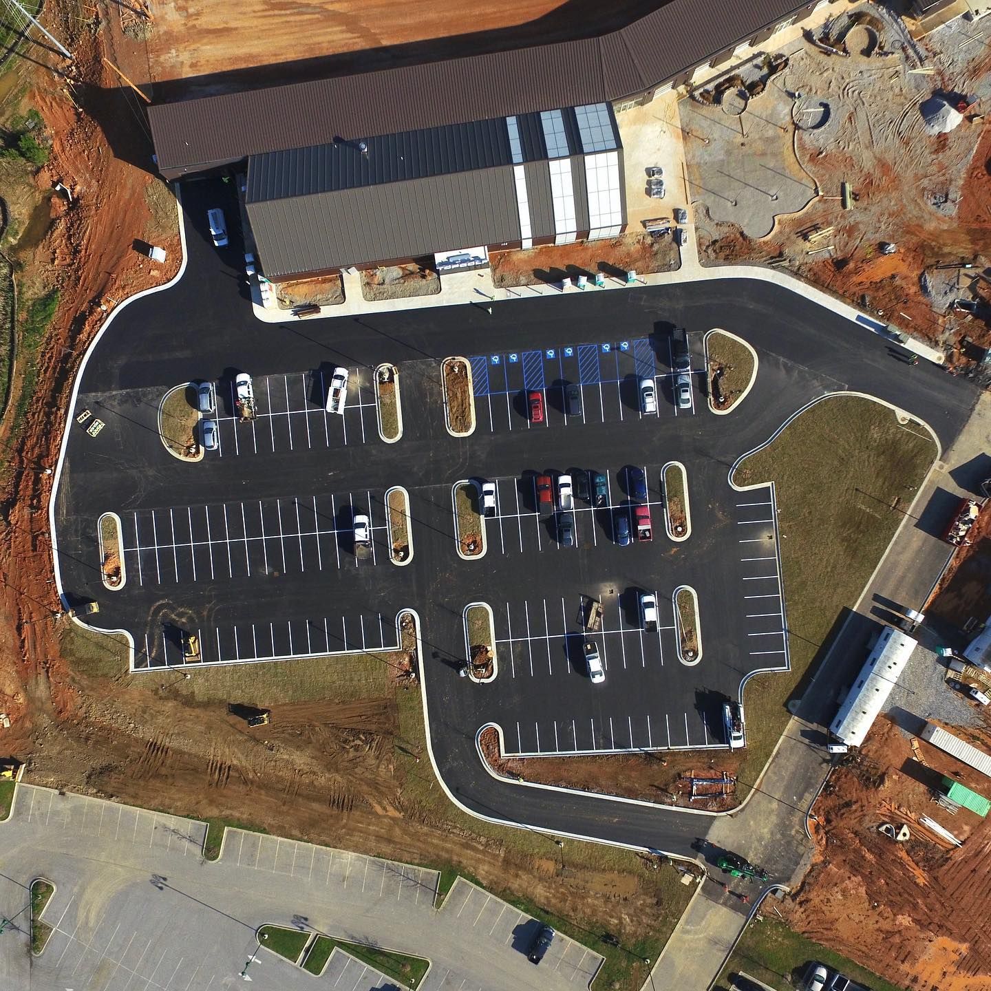 An aerial view of a parking lot with a building in the background