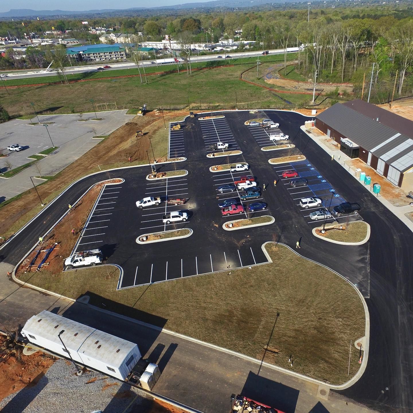 An aerial view of a parking lot with cars parked in it