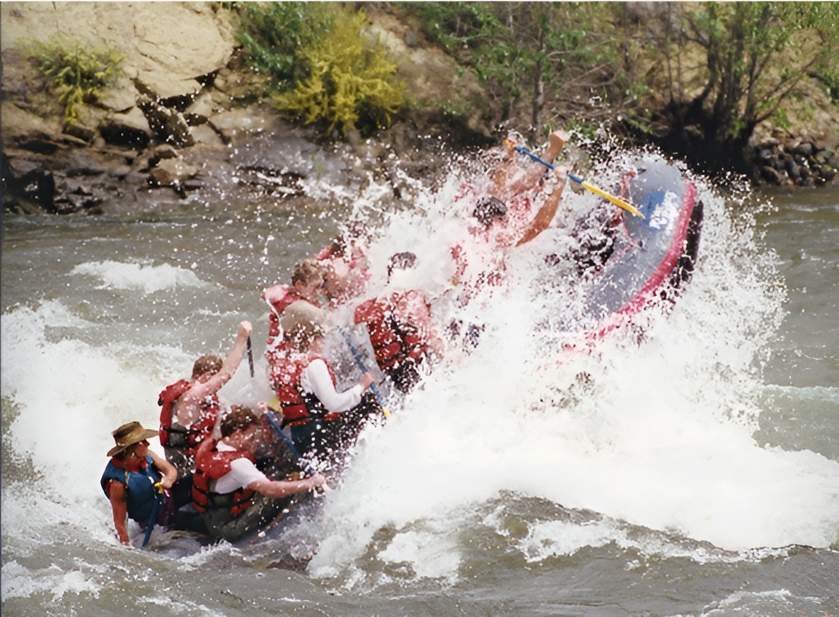 A group of people are rafting down a river in a raft that says jeep on it