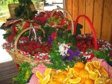A bunch of baskets filled with fruit and flowers are sitting on a table.