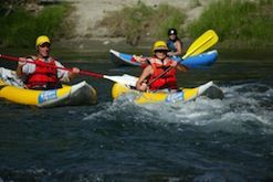 A group of people are paddling kayaks down a river.