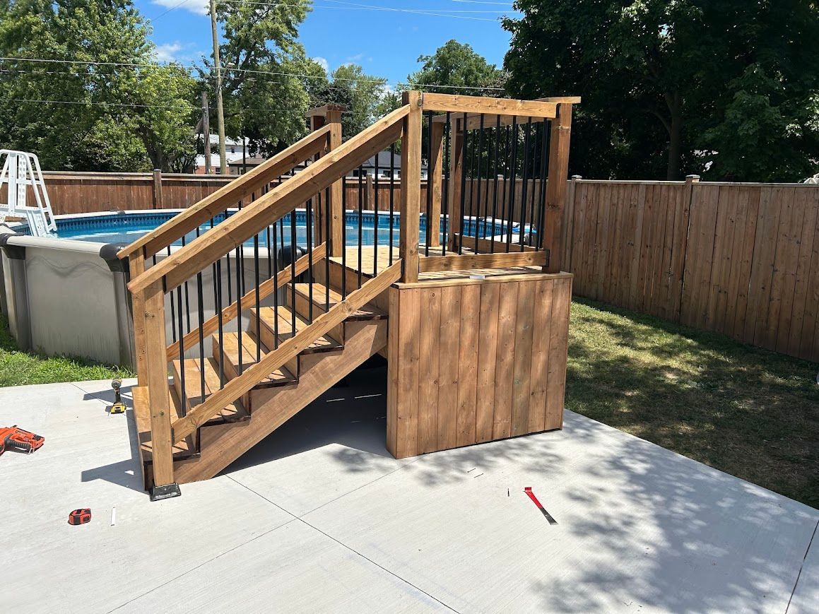 Wooden deck and stairs leading to an above-ground swimming pool.