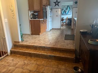 Kitchen with tile floor, three steps down, and wooden cabinets.