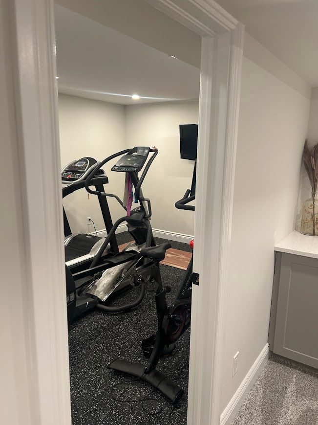 View of home gym with exercise equipment inside a doorway.