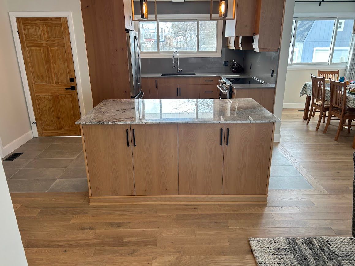 Kitchen with wood cabinets and granite countertop island; open to dining area.