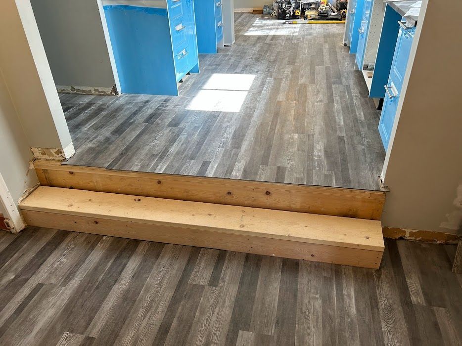 A wooden staircase is being built into a wooden floor in a room.