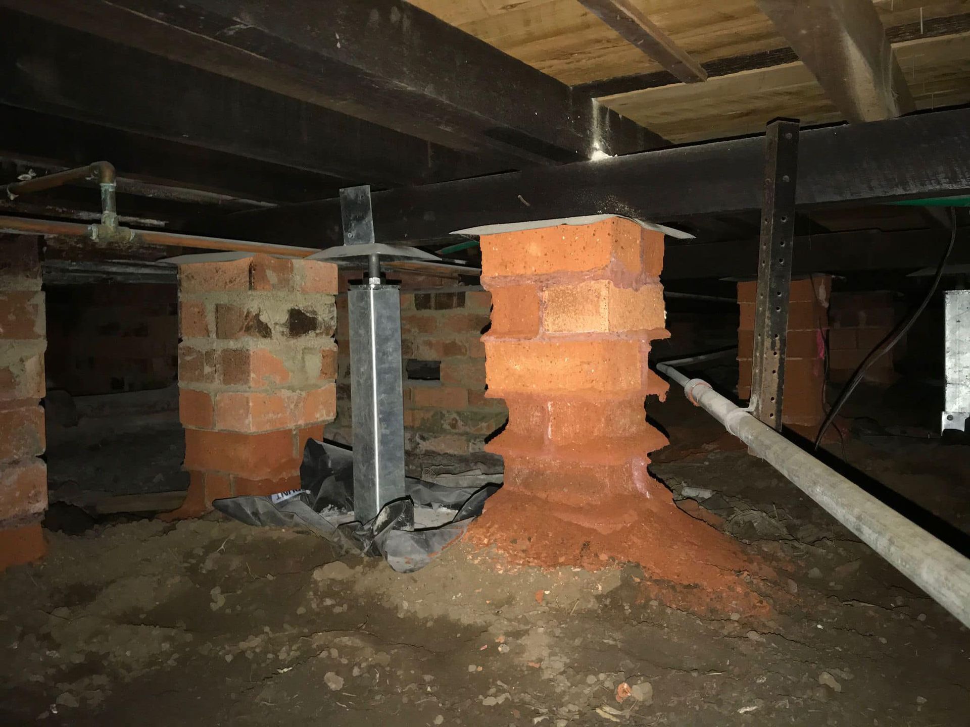 A brick pillar is sitting in the middle of a basement.