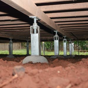 The underside of a wooden deck with a concrete base