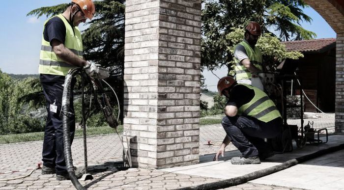 A group of construction workers are working on a brick wall.