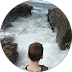 A man is standing in a circle looking at the ocean.