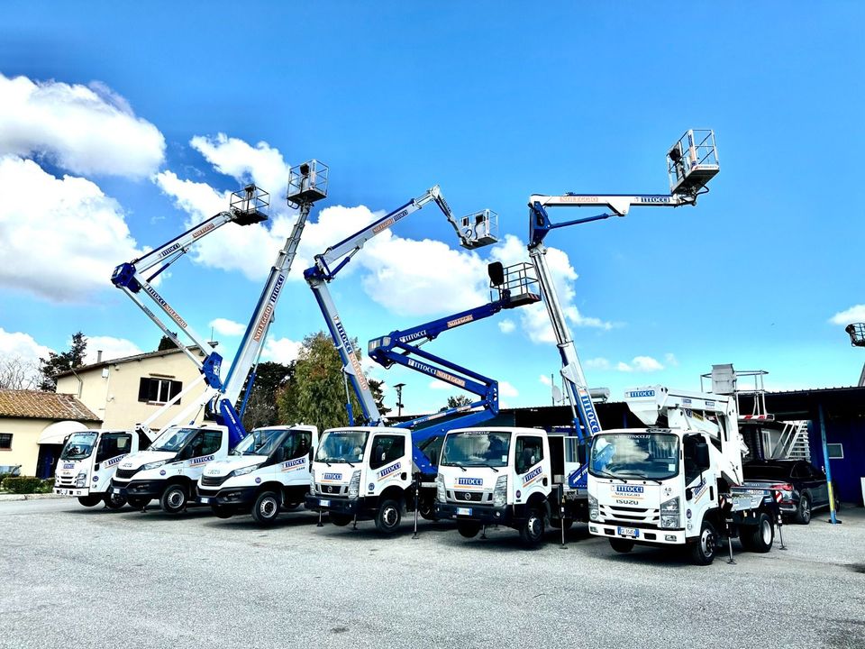 Un uomo è seduto sul sedile posteriore di un'auto e sta usando un computer portatile e parlando al cellulare.